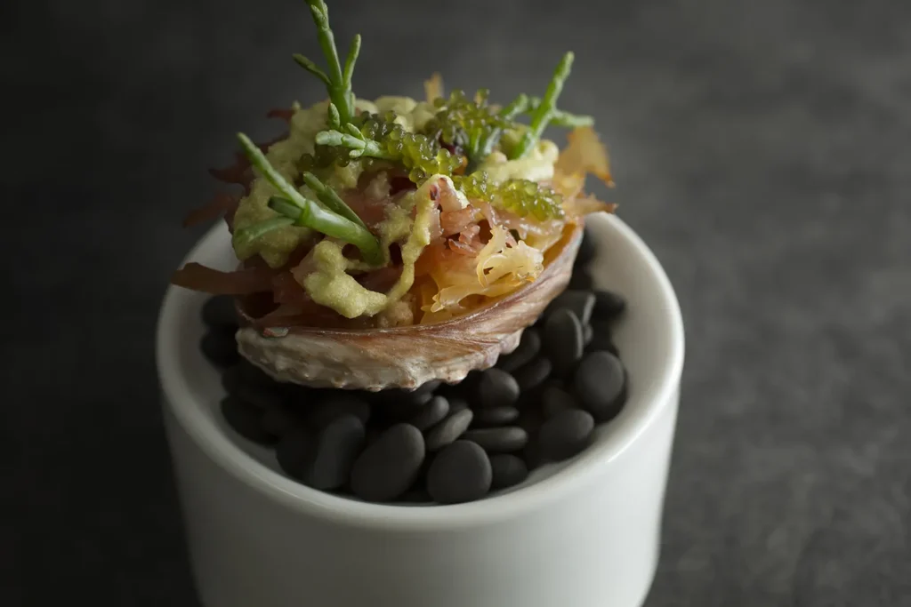A vegan fine dining dish with sea asparagus and sea grapes